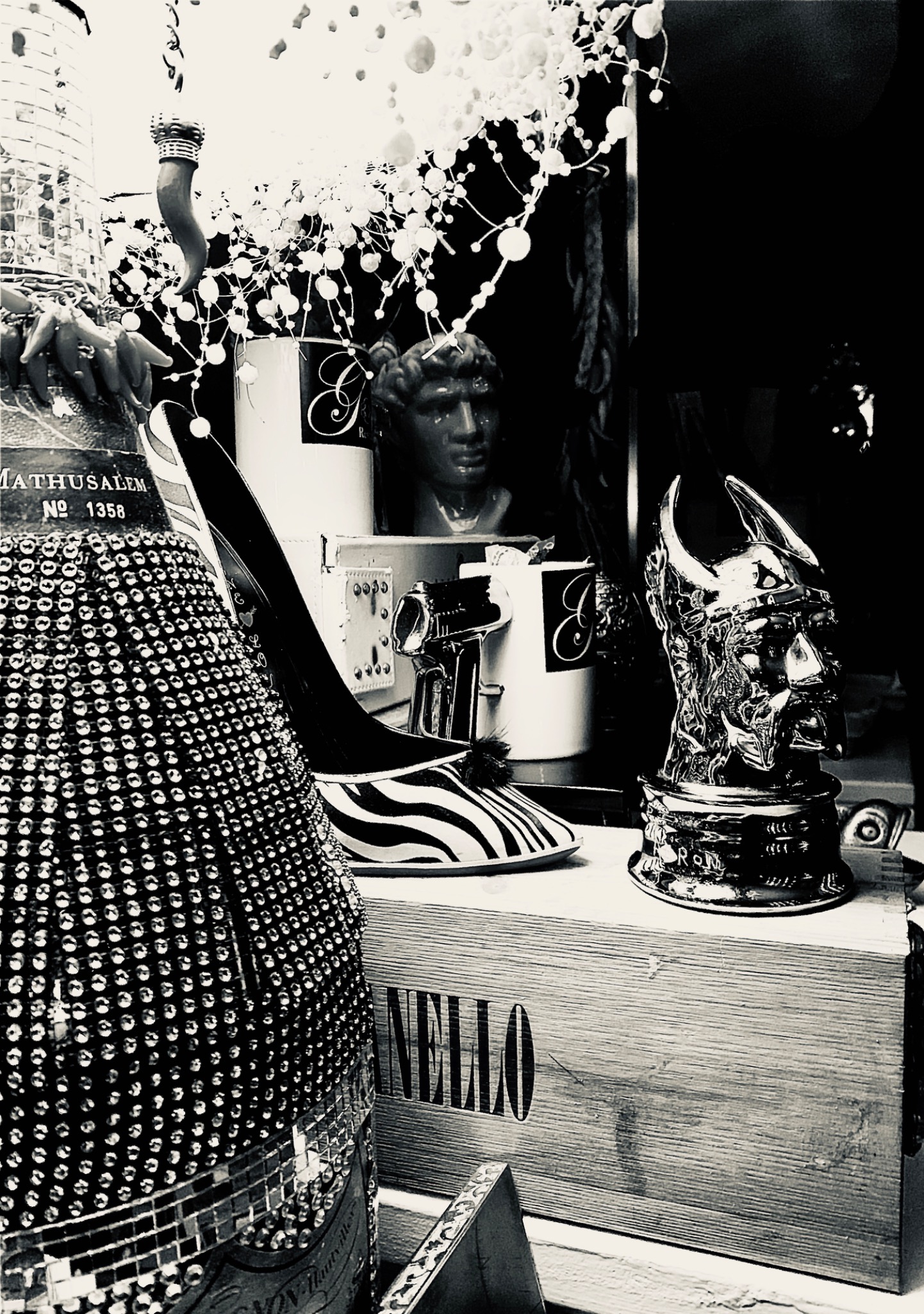 Black and white restaurant details with decorative bottles, a chandelier and a sculpted head