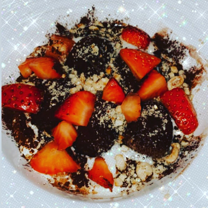 Chocolate dessert with sliced strawberries and a pale crumble