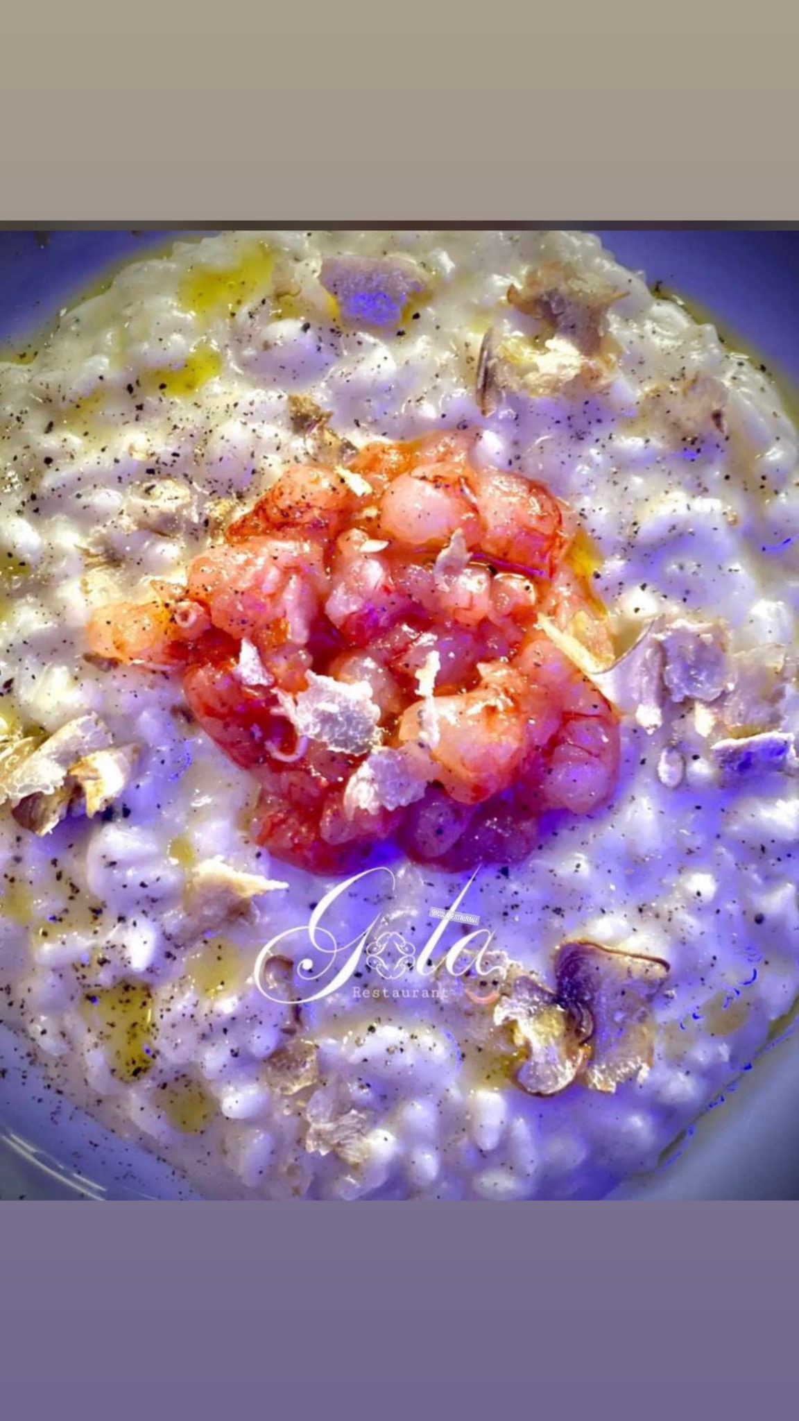 A creamy risotto topped with finely chopped pink seafood and truffle shavings